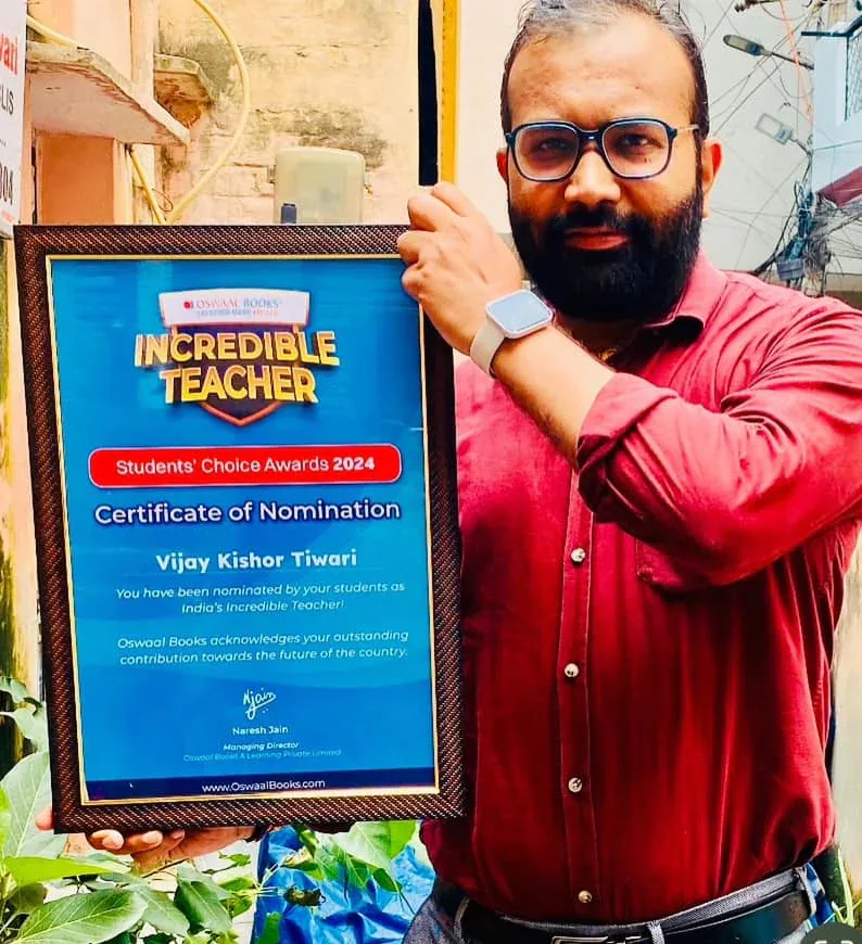Vijay Kishor Tiwari holding his Oswaal Books Incredible Teacher certificate of nomination, Students' Choice Awards 2024