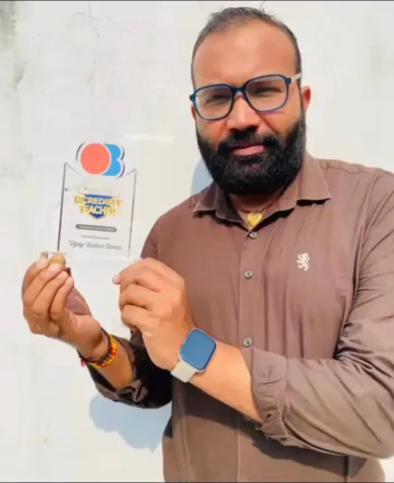 Vijay Kishor Tiwari holding his Oswaal Books Incredible Teacher trophy