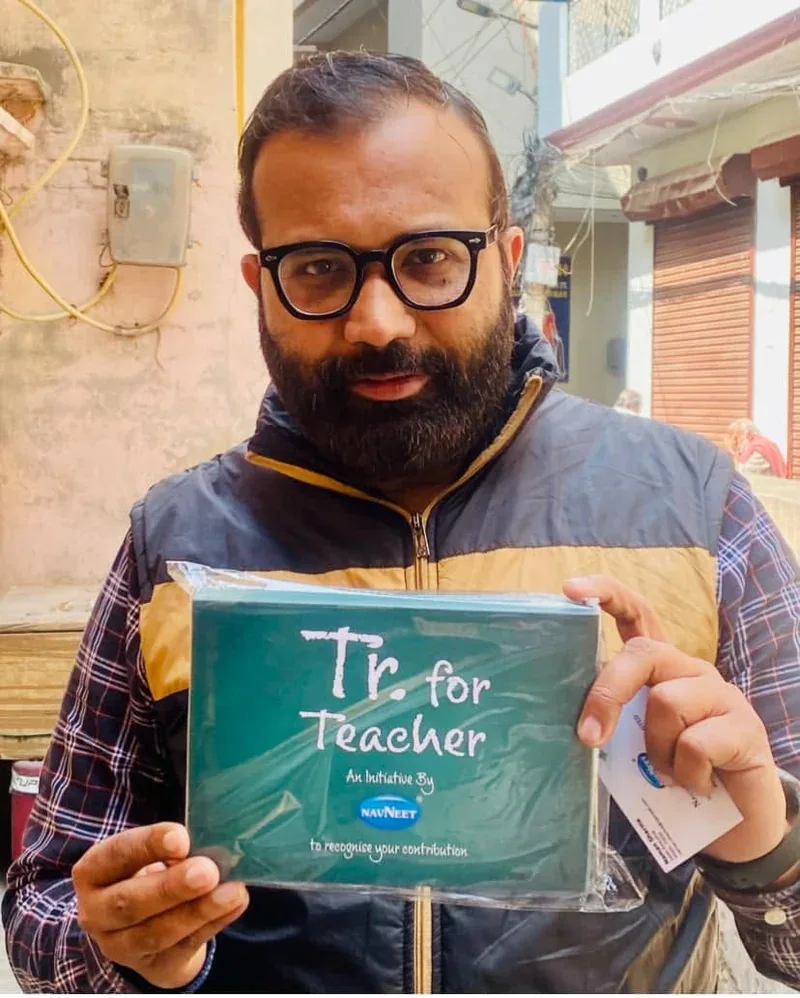 Vijay Kishor Tiwari holding the Tr. for Teacher recognition from Navneet