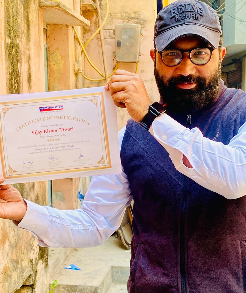 Vijay Kishor Tiwari holding his Viva Education certificate of participation for the Teacher's Day essay writing contest, September 2022
