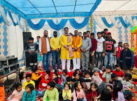 Vijay Kishor Tiwari with guests, students and children at a community celebration under a decorated tent