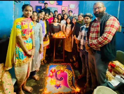 Students and Vijay sir standing around a rangoli with lit diyas at Vijay Classes
