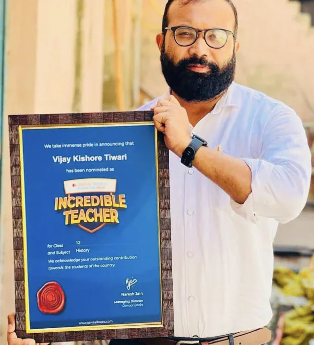 Vijay Kishor Tiwari, founder of Vijay Classes, holding his Oswaal Books Incredible Teacher award for Class 12 History